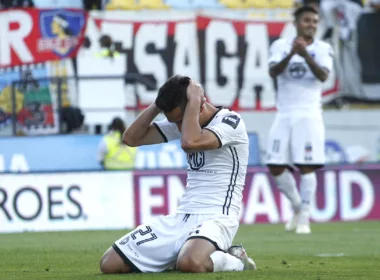 Branco Provoste arrodillado en el piso se toma su cabeza y se lamenta en pleno partido con la camiseta de Colo-Colo durante la temporada 2020.