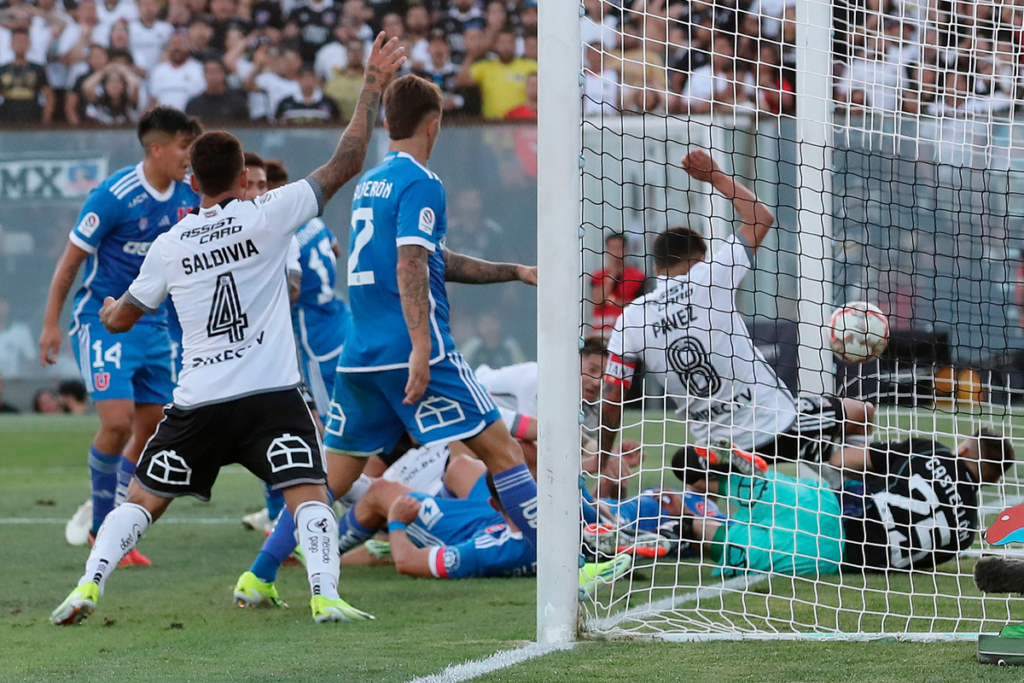 Un balón entra en el arco de Universidad de Chile tras ser empujado por la mano por Esteban Pavez, futbolista de Colo-Colo y capitán del equipo durante la temporada 2024, cuyo gol fue anulado posteriormente por el VAR.