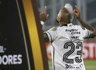 Arturo Vidal de espalda y con los dedos apuntando hacia el cielo con la camiseta de Colo-Colo. A mano izquierda se puede ver un pedazo de cartel de la Copa Libertadores 2024.