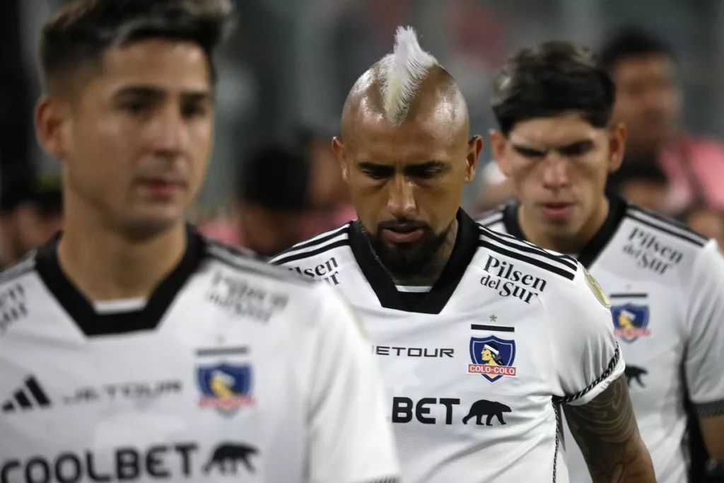 Los futbolistas Arturo Vidal y Carlos Palacios se retiran con la mirada cabizbaja tras disputar un partido con la camiseta de Colo-Colo.