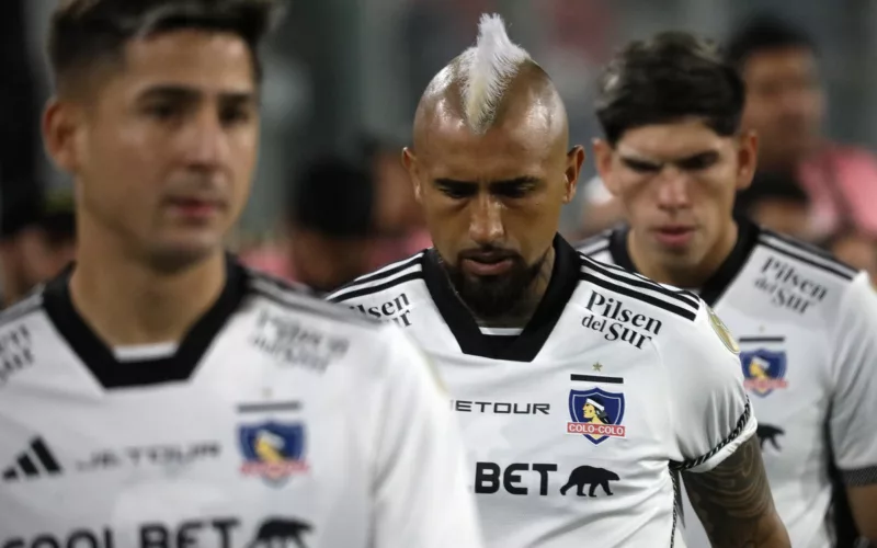 Los futbolistas Arturo Vidal y Carlos Palacios se retiran con la mirada cabizbaja tras disputar un partido con la camiseta de Colo-Colo.