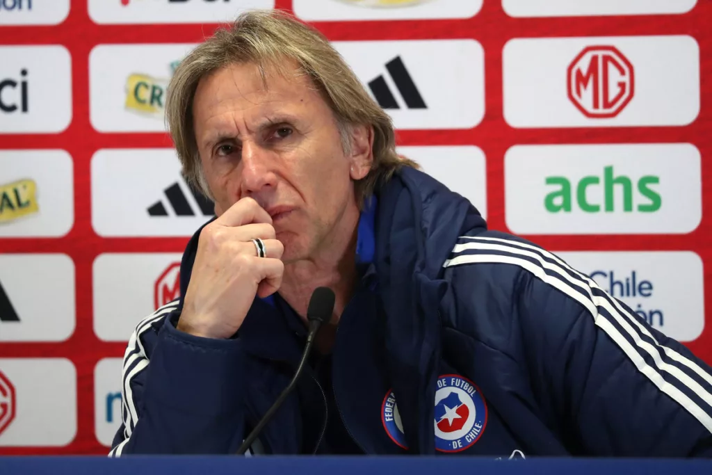 Ricardo Gareca bastante pensativo y con la mano en su boca en plena conferencia de prensa con el buzo de la Selección Chilena.