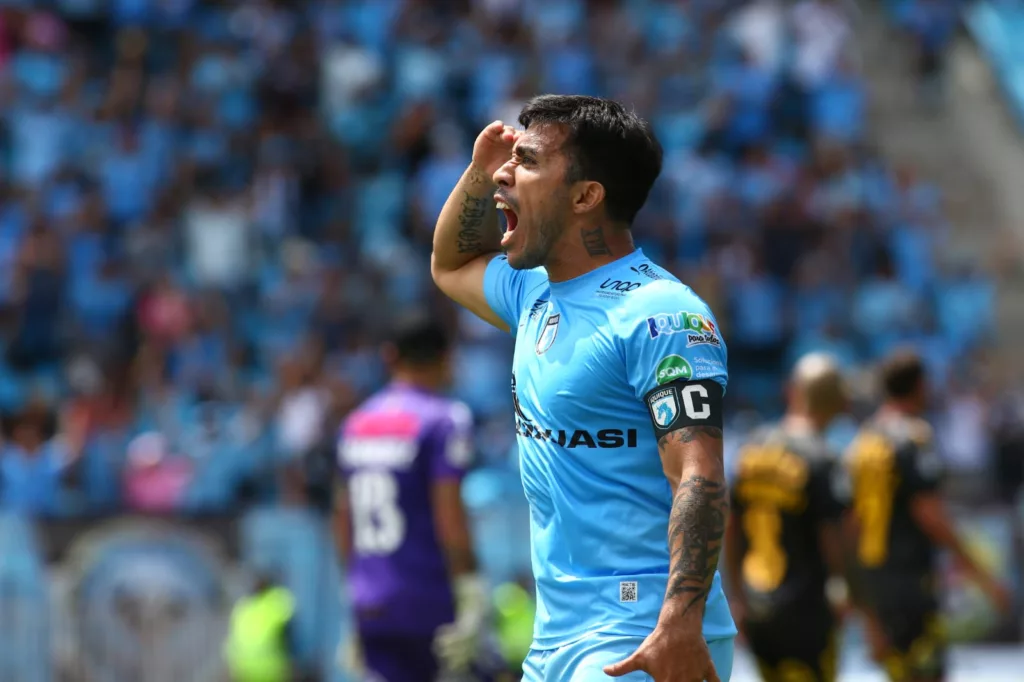 Primer plano a Edson Puch celebrando con una mano en la cabeza un gol con la camiseta de Deportes Iquique.