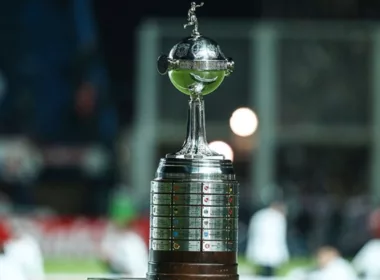 Primer plano al trofeo de la Copa Libertadores en el borde de una cancha.