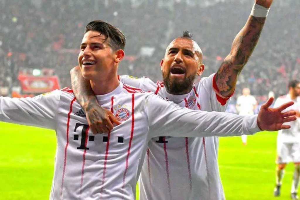 Primer plano a James Rodríguez y Arturo Vidal celebrando un gol con la camiseta del Bayern Múnich.