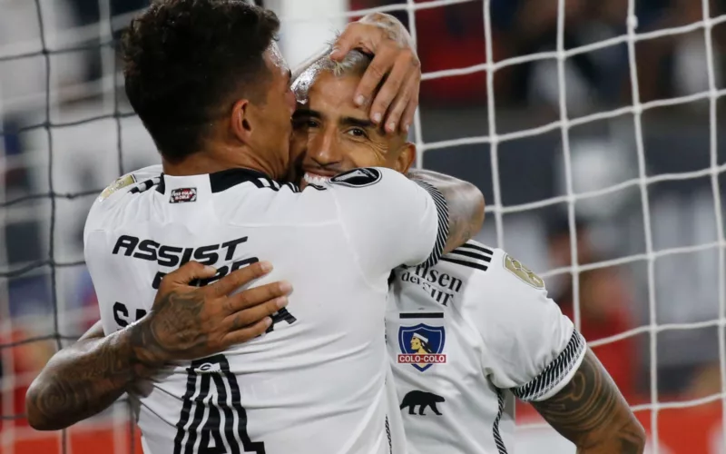 Primer plano a Alan Saldivia y Arturo Vidal celebrando un gol con la camiseta de Colo-Colo.