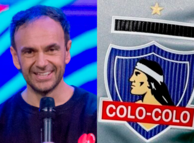 Primer plano al rostro sonriente del periodista Rodrigo Sepúlveda mientras sostiene un micrófono, mientras que a mano derecha se observa el escudo de Colo-Colo.