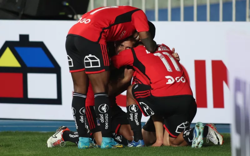Futbolistas de Colo-Colo se abrazan y celebran un gol a finales de la temporada 2023.