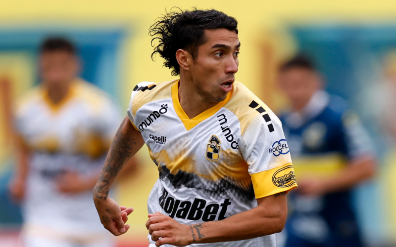 Luciano Cabral defendiendo la camiseta de Coquimbo Unido durante la temporada 2024. Tiene la mirada puesta en un objetivo que observa de reojo.