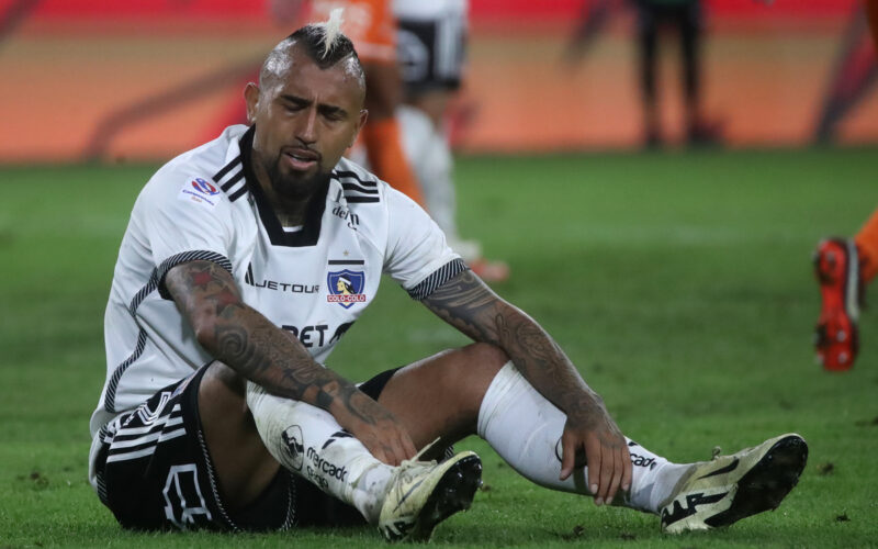 Arturo Vidal sentado sobre el césped de la cancha principal del Estadio Monumental.