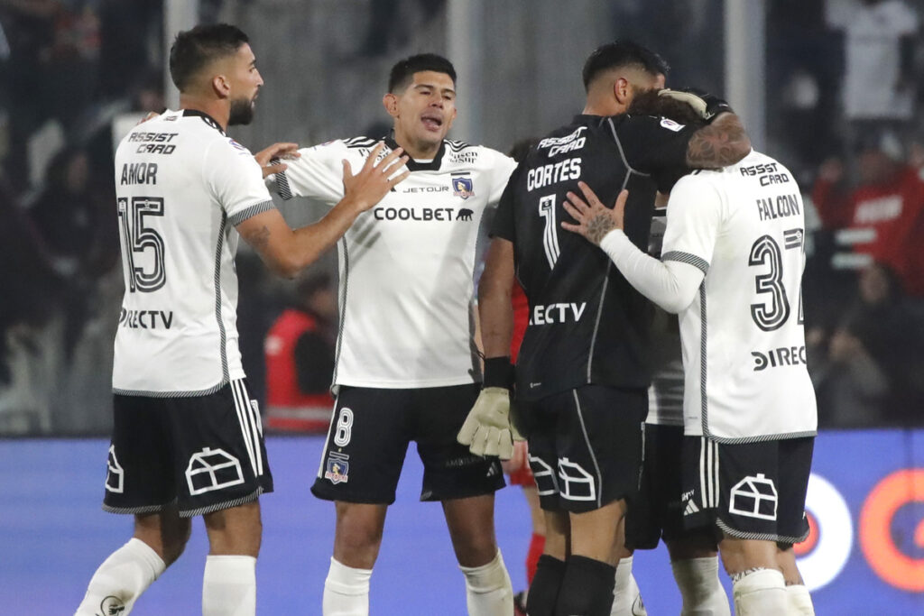 Jugadores de Colo-Colo abrazándose en la cancha.