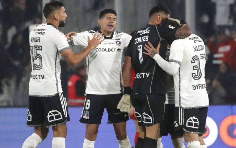 Jugadores de Colo-Colo abrazándose en la cancha.