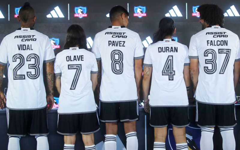 Futbolistas del plantel femenino y masculino de Colo-Colo muestran de espaldas la camiseta de la temporada 2024.