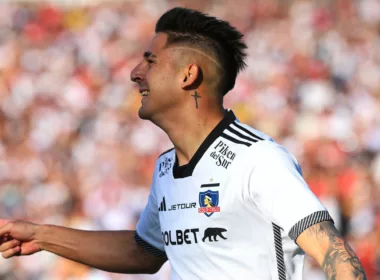 Guillermo Paiva de perfil celebra un gol con la camiseta de Colo-Colo con una notoria sonrisa en su rostro.