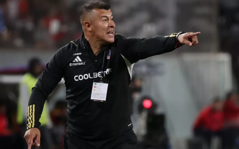 Jorge Almirón reparte una instrucción con su brazo izquierdo apuntando a un objetivo en pleno partido dirigiendo a Colo-Colo.