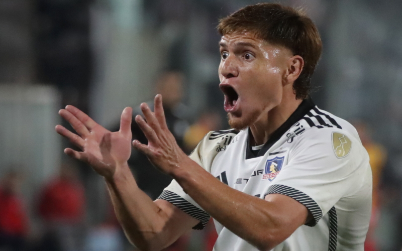 Leonardo Gil levanta sus brazos y reclama eufórico una situación con la camiseta de Colo-Colo durante la temporada 2024.