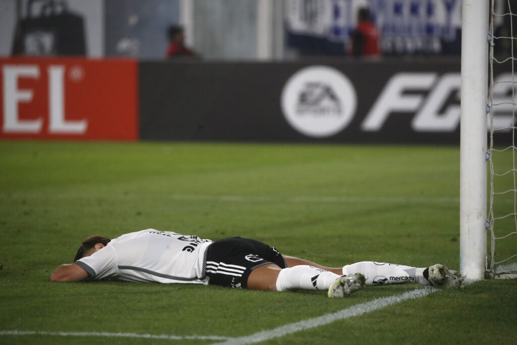Leonardo Gil desparramado en el piso en pleno partido con la camiseta de Colo-Colo en el Estadio Monumental.
