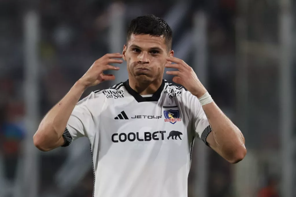 Primer plano a Lucas Cepeda con las mejillas infladas celebrando su primer gol con la camiseta de Colo-Colo.