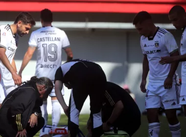 Jugadores de Colo-Colo mientras atendían a un futbolista en el campo de juego.