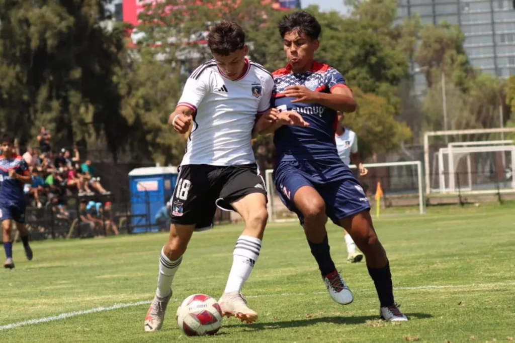 Nahuel Flores con la camiseta de Colo-Colo disputando un balón ante un jugador de Deportes Recoleta en la Copa Futuro.