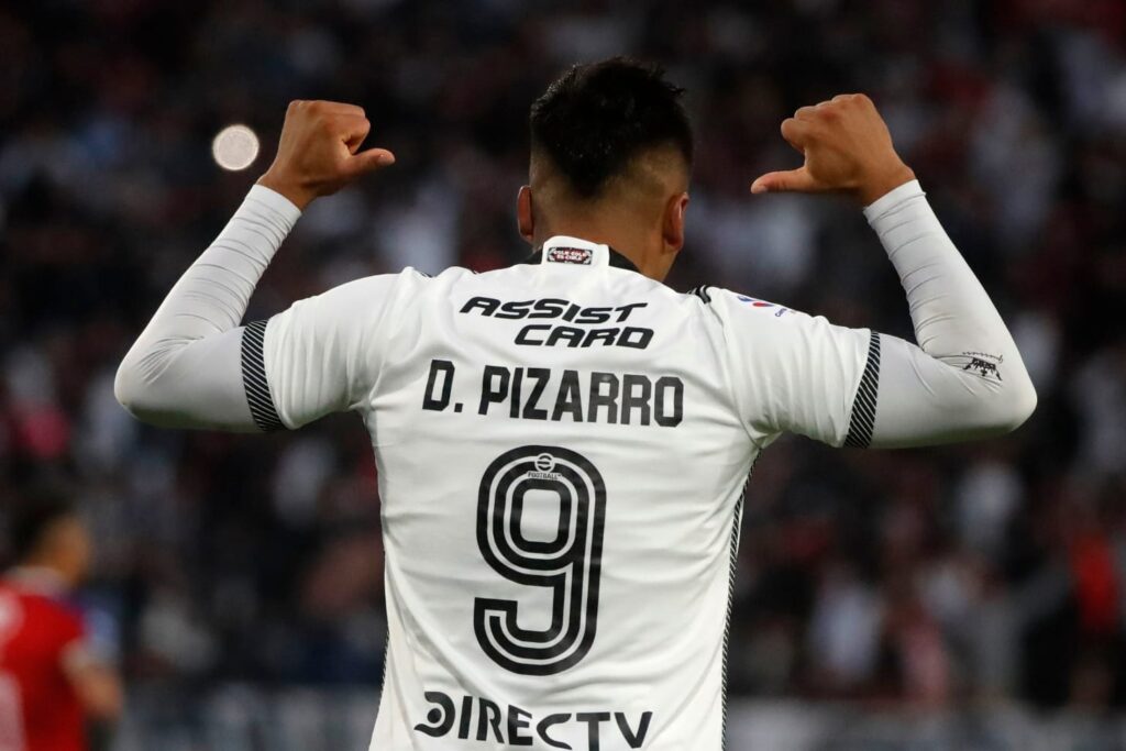 Damián Pizarro de espaldas apuntando a su camiseta tras convertir su primer gol ante Unión la Calera.