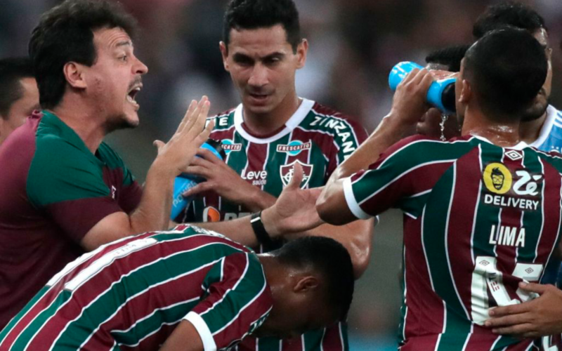 Futbolistas de Fluminense se reúnen y reciben una instrucción de su entrenador en pleno partido.