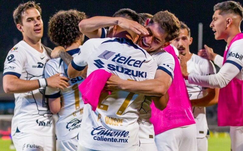 Jugadores de Pumas de la UNAM abrazándose.