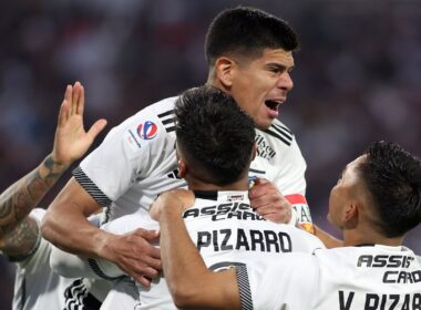 Jugadores de Colo-Colo abrazados celebrando un gol.