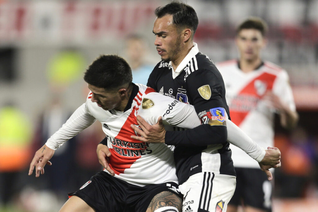 Gabriel Suazo disputando un balón con un Agustín Palavecino en duelo de River Plate y Colo-Colo.