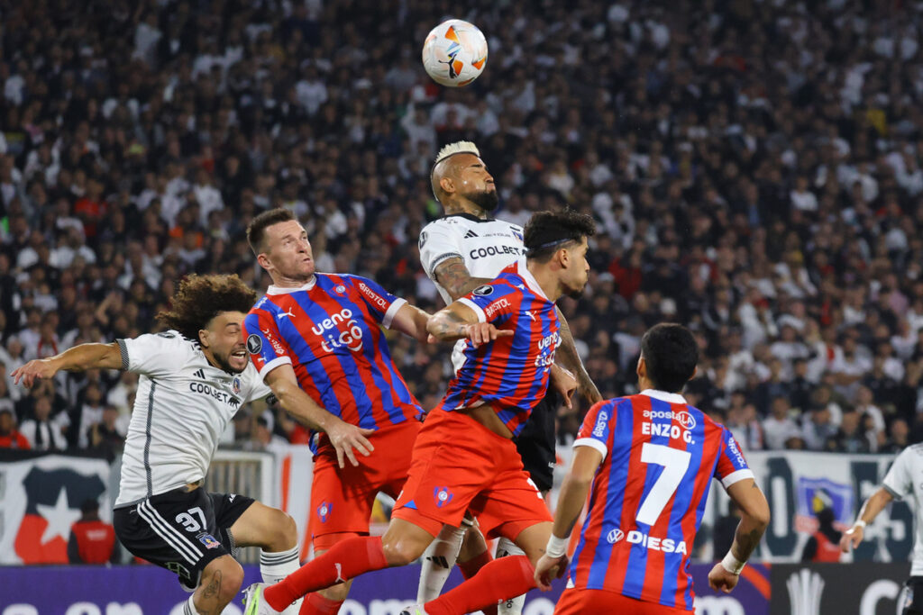 Jugadores de Colo-Colo y Cerro Porteño disputando un balón aéreo.