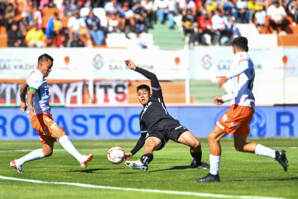 Damián Pizarro anotando desde el piso un gol a Cobresal.