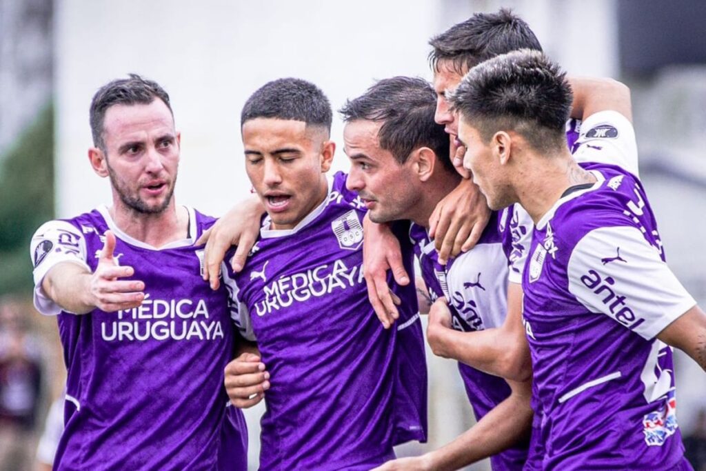 Jugadores de Defensor Sporting abrazando a Octavio Rivero tras anotar un gol.