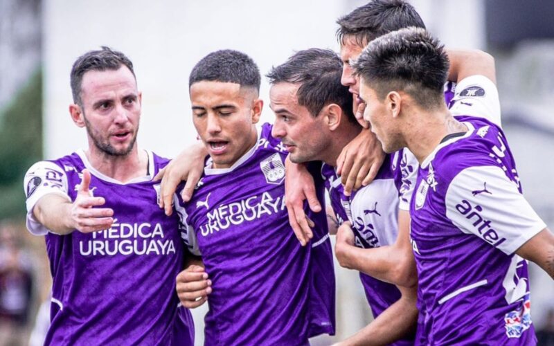 Jugadores de Defensor Sporting abrazando a Octavio Rivero tras anotar un gol.