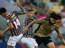 Maximiliano Falcón disputando el balón con jugadores de Fluminense en el duelo por Copa Libertadores.