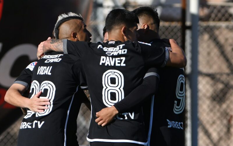 Plantel de Colo-Colo celebrando un gol con camiseta negra en el Estadio El Cobre de El Salvador.