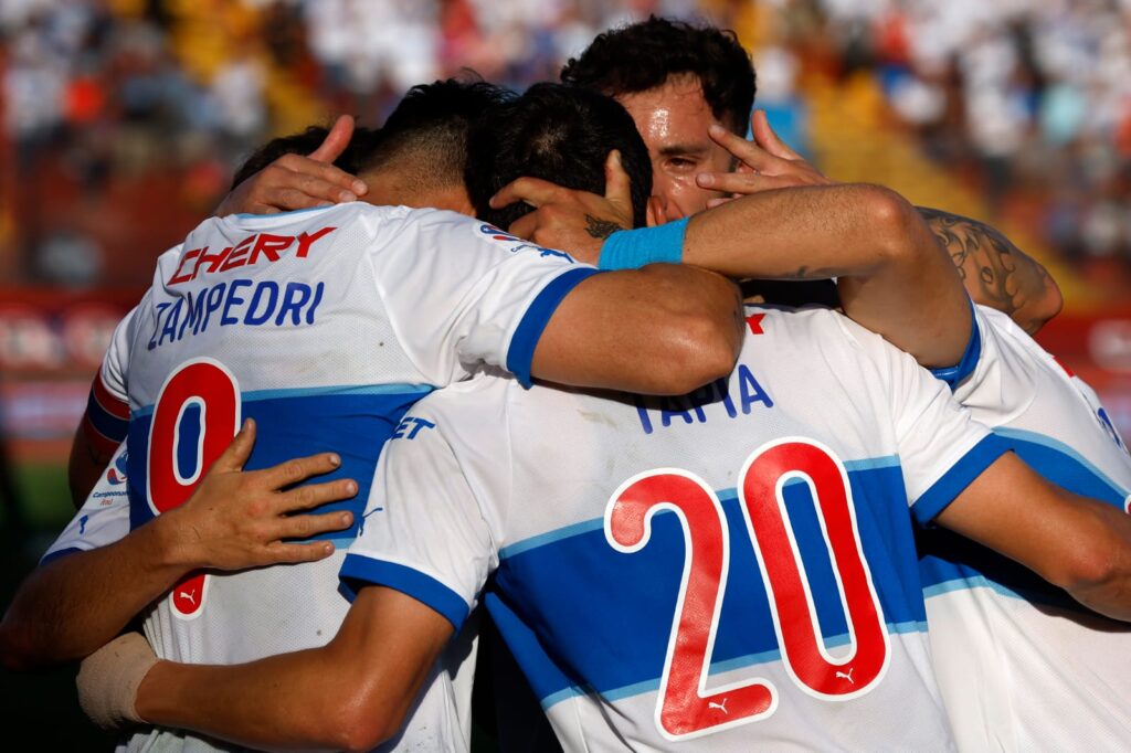 Primer plano a jugadores de Universidad Católica abrazados celebrando un gol.