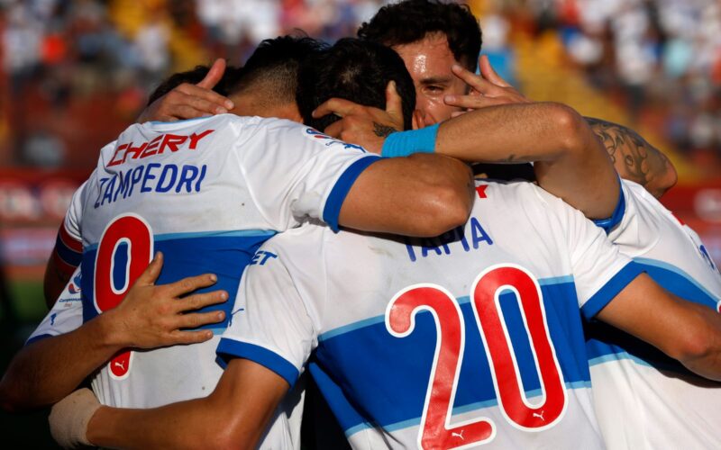 Primer plano a jugadores de Universidad Católica abrazados celebrando un gol.