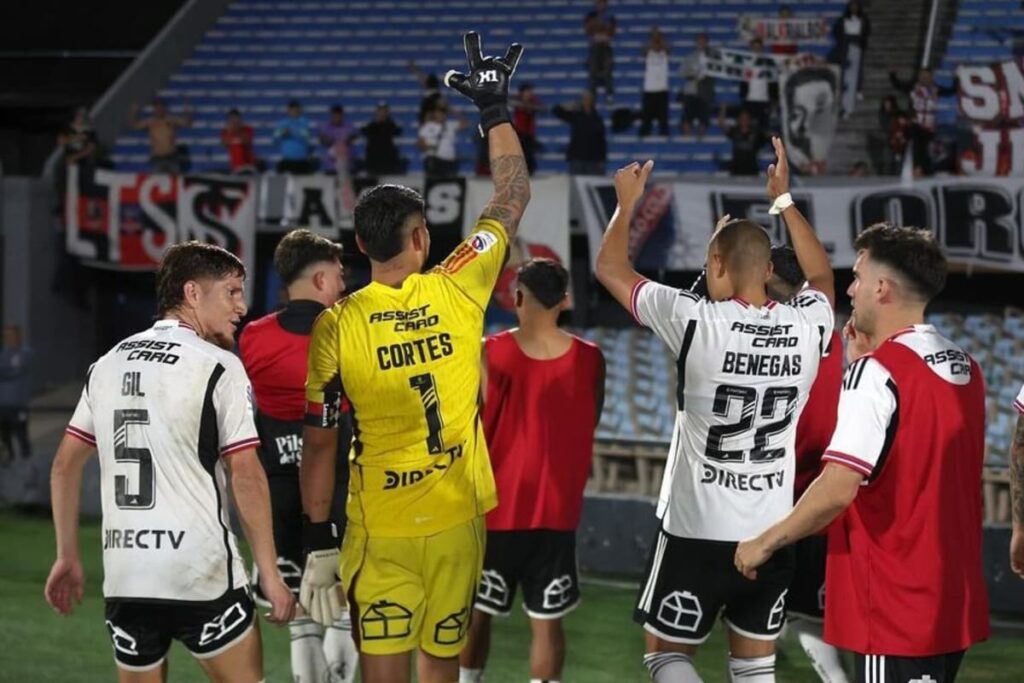 Primer plano a jugadores de Colo-Colo celebrando con la hinchada en Uruguay.