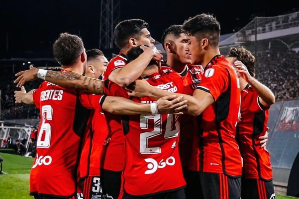 Plantel de Colo-Colo celebrando un gol con camiseta roja.
