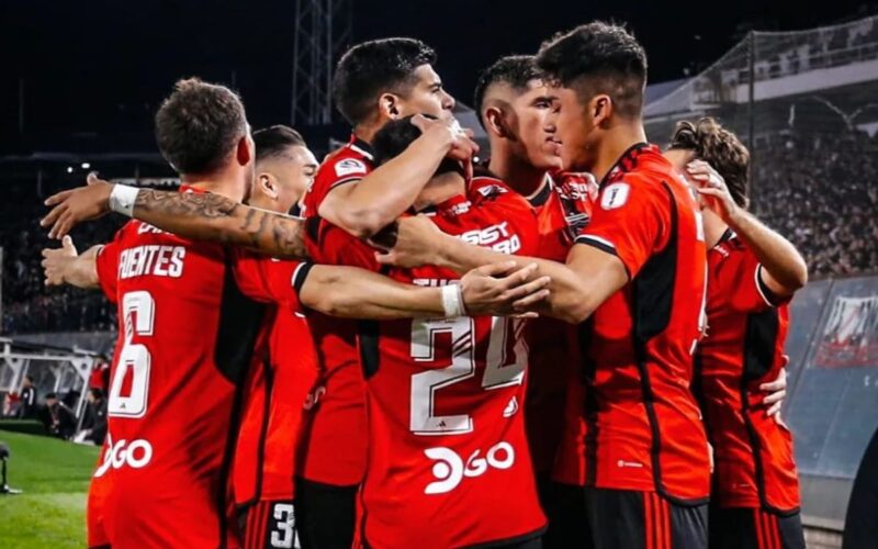 Plantel de Colo-Colo celebrando un gol con camiseta roja.