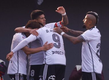 Jugadores de Colo-Colo celebrando abrazados un gol contra Audax Italiano.