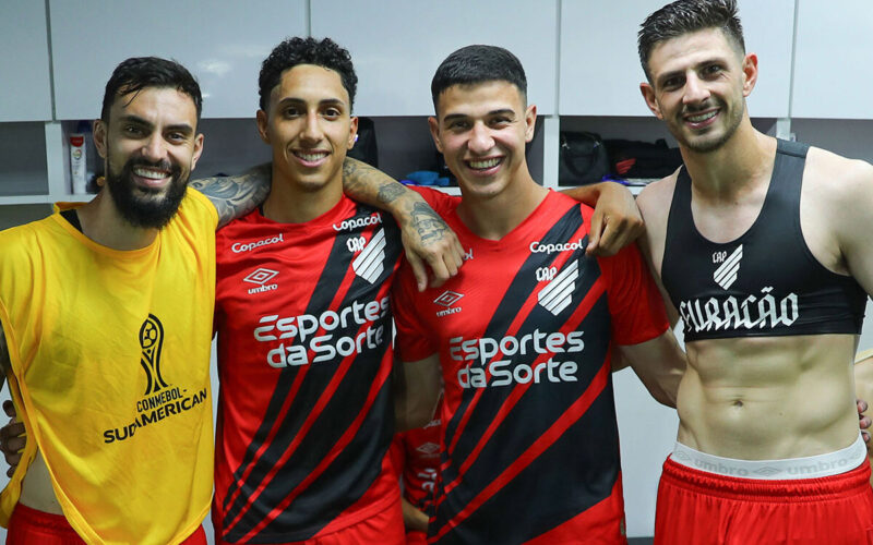 Jugadores de Athletico Paranaense abrazados.