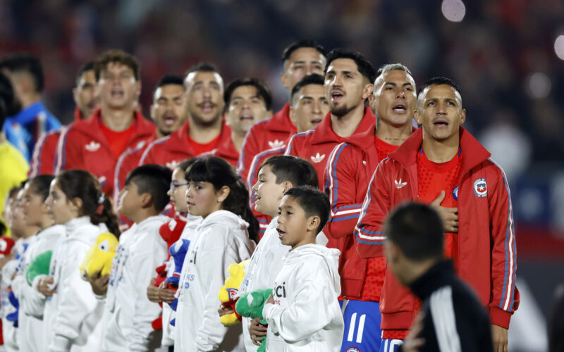 Jugadores de la Selección Chilena formados cantando el himno nacional.