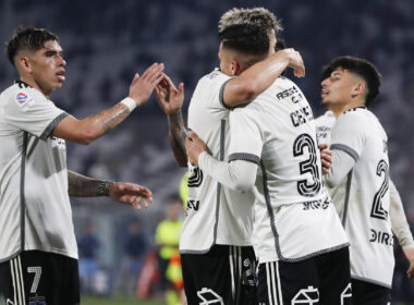 Jugadores de Colo-Colo abrazados celebrando un gol.