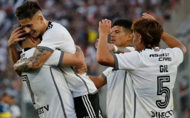 Jugadores de Colo-Colo celebrando abrazados un gol en el Estadio Monumental.