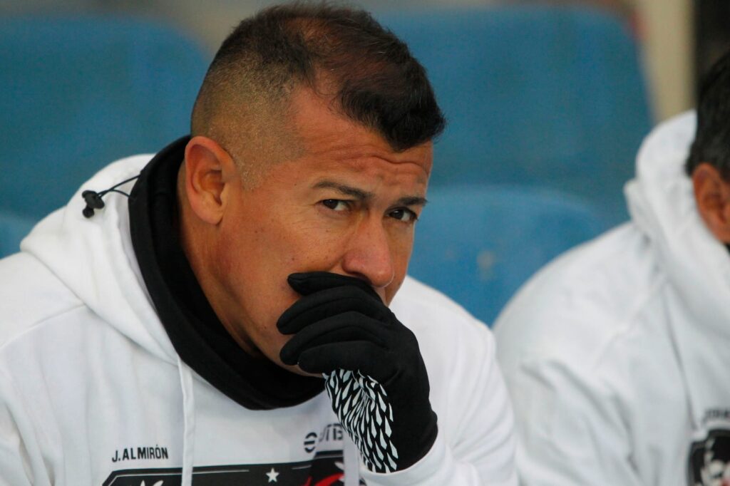 Jorge Almirón con cara de preocupación e indumentaria de Colo-Colo.
