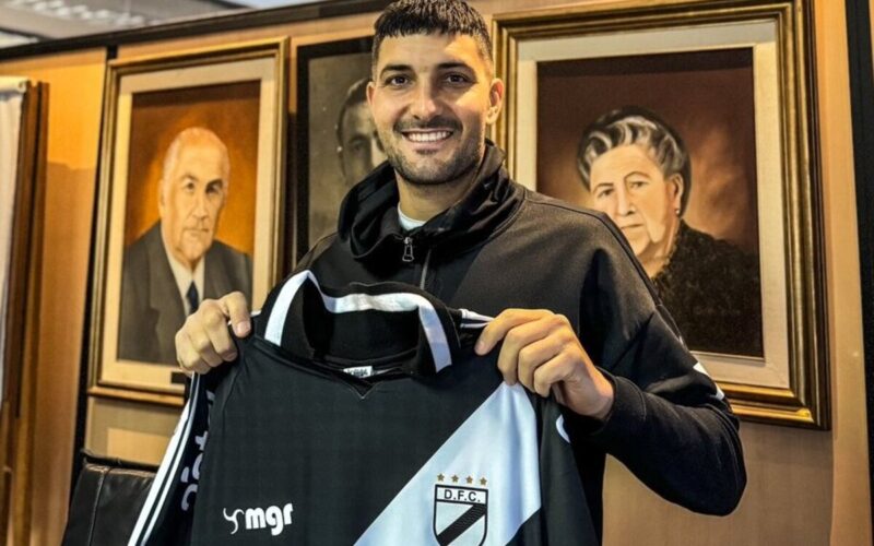 Primer plano de Nicolás Blandi con la camiseta de Danubio en sus manos.