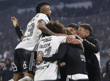 Jugadores de Colo-Colo abrazados celebrando un gol.