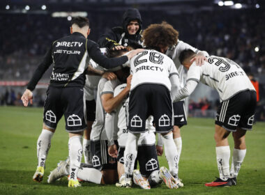 Jugadores de Colo-Colo abrazados celebrando un gol.