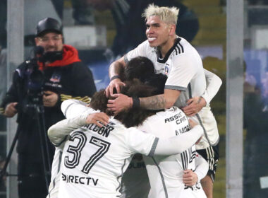 Jugadores de Colo-Colo abrazados celebrando un gol.